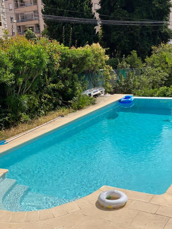 a large blue swimming pool with a ring in the water at Maisonnette Cagnes in Cagnes-sur-Mer