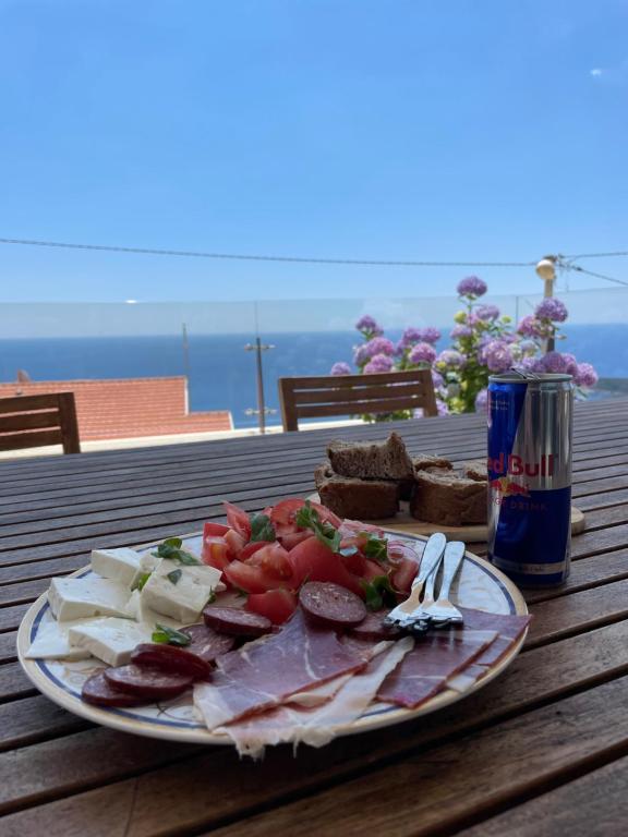 a plate of food with meat and cheese and a can of soda at Apartments Villa Sveti Nikola in Budva