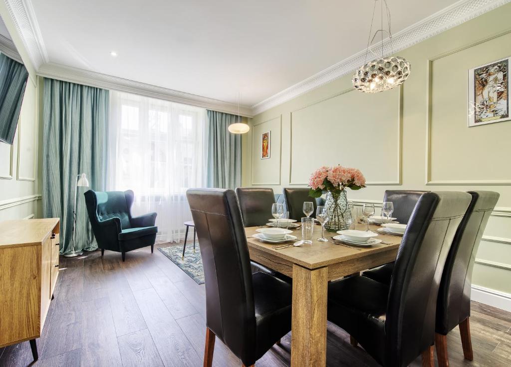 a dining room with a table and black chairs at Apartament Etiuda - ACCO RENT in Sopot