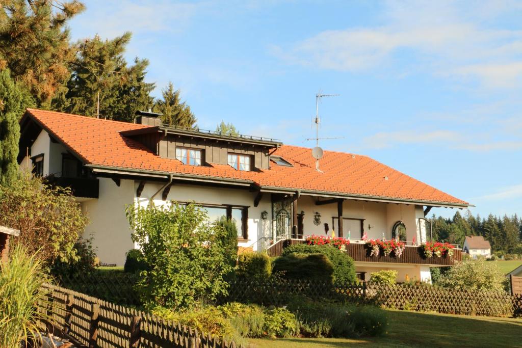 a house with an orange roof and a fence at Ferienwohnung am Süd-Schwarzwald 1 in Murg