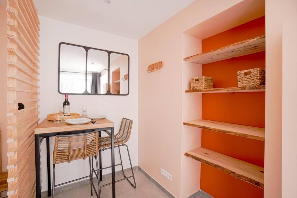 a small dining room with a table and shelves at Studio de charme - calme, discret &amp; cosy - 3&#39; RER in Évry-les-Châteaux