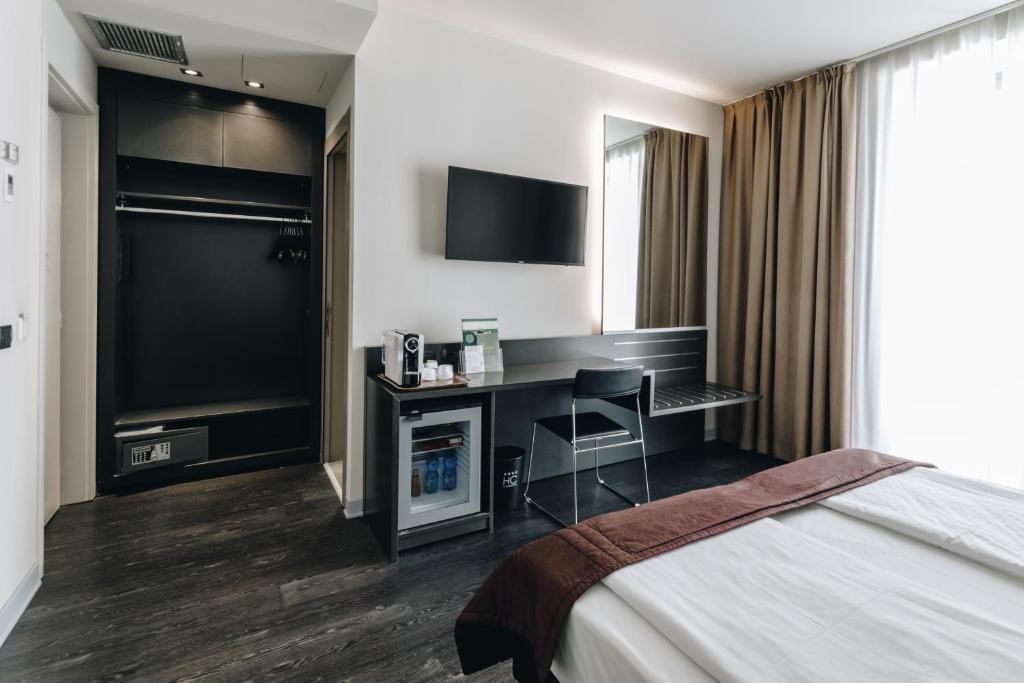 クレモナにあるHotel Continentalのデスクとベッドが備わるホテルルームです。