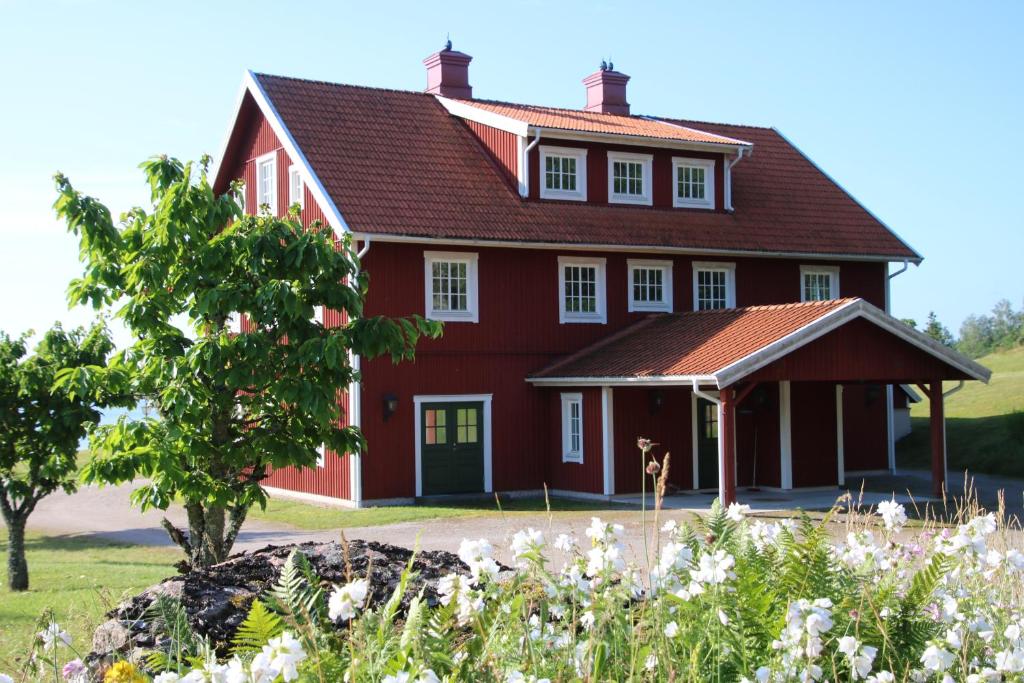 uma casa vermelha com um telhado vermelho em Värmvik Gårdskontor em Västervik