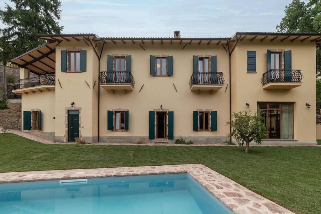 Villa con piscina frente a una casa en Villa Gina Umbria Luxury Retreat, en SantʼAnatolia di Narco