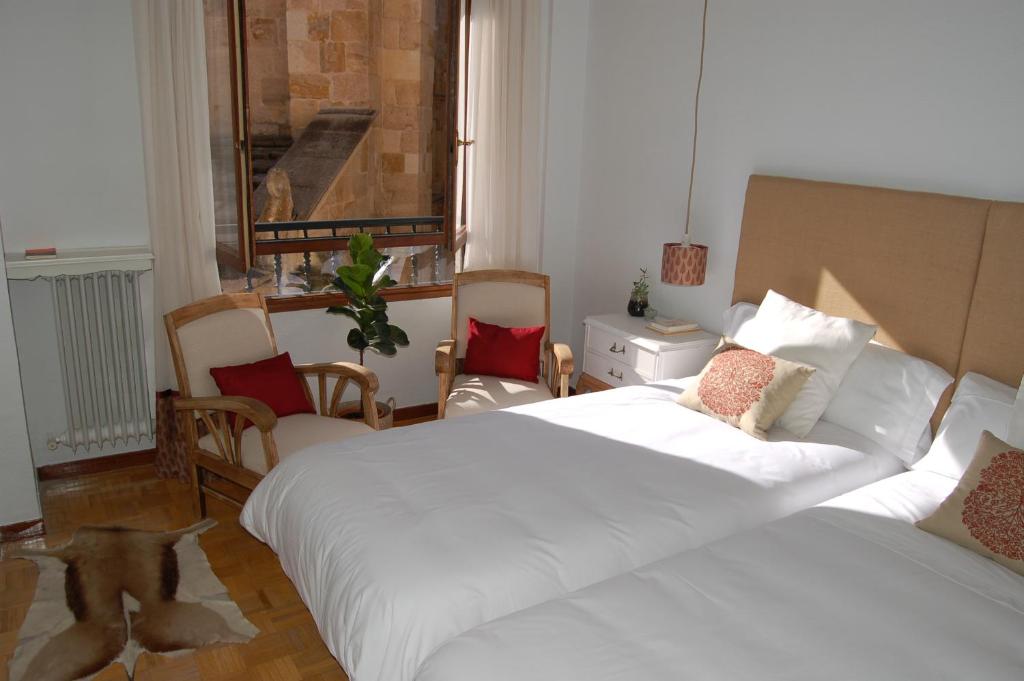 - une chambre avec un grand lit et un chien debout à l'étage dans l'établissement La Casa de Zamora, à Zamora