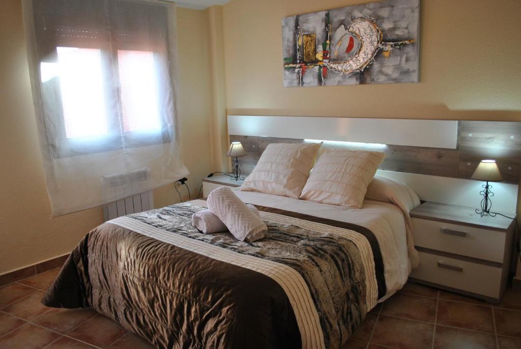 - une chambre avec un grand lit, 2 tables et 2 fenêtres dans l'établissement Viviendas de uso turisitco Dulcinea, à Ventas con Peña Aguilera