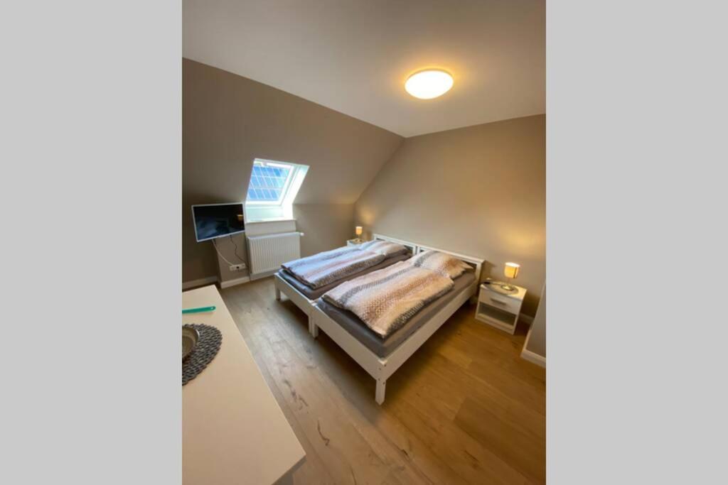 um quarto com uma cama e uma televisão em Ferienwohnung Zwischen Eider u. Elbe em Eddelak