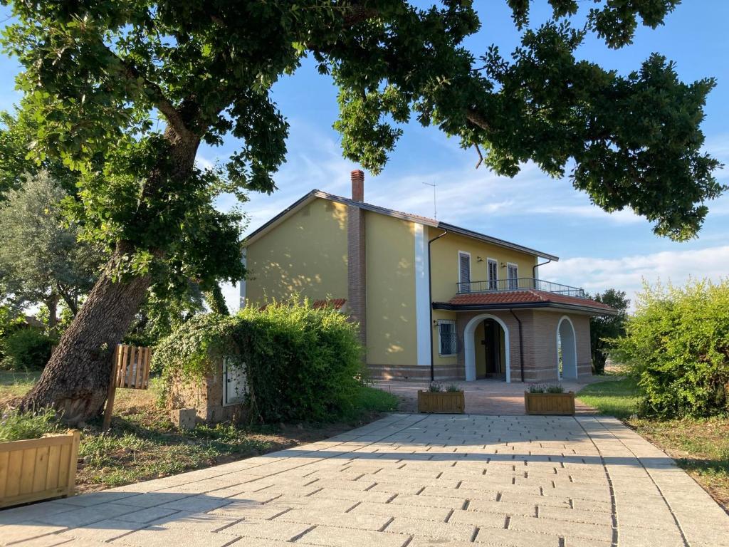 una vista exterior de una casa con un árbol en Agriturismo Tenuta della Madama, en Venticano