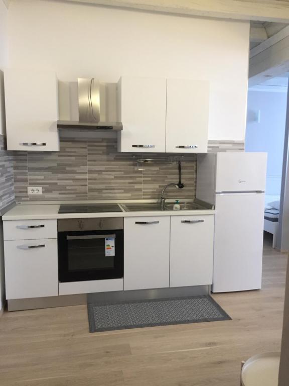 Una cocina con gabinetes blancos y un horno de estufa. en RESIDENZA SERENA SUITE-Centro Storico, en Mantua