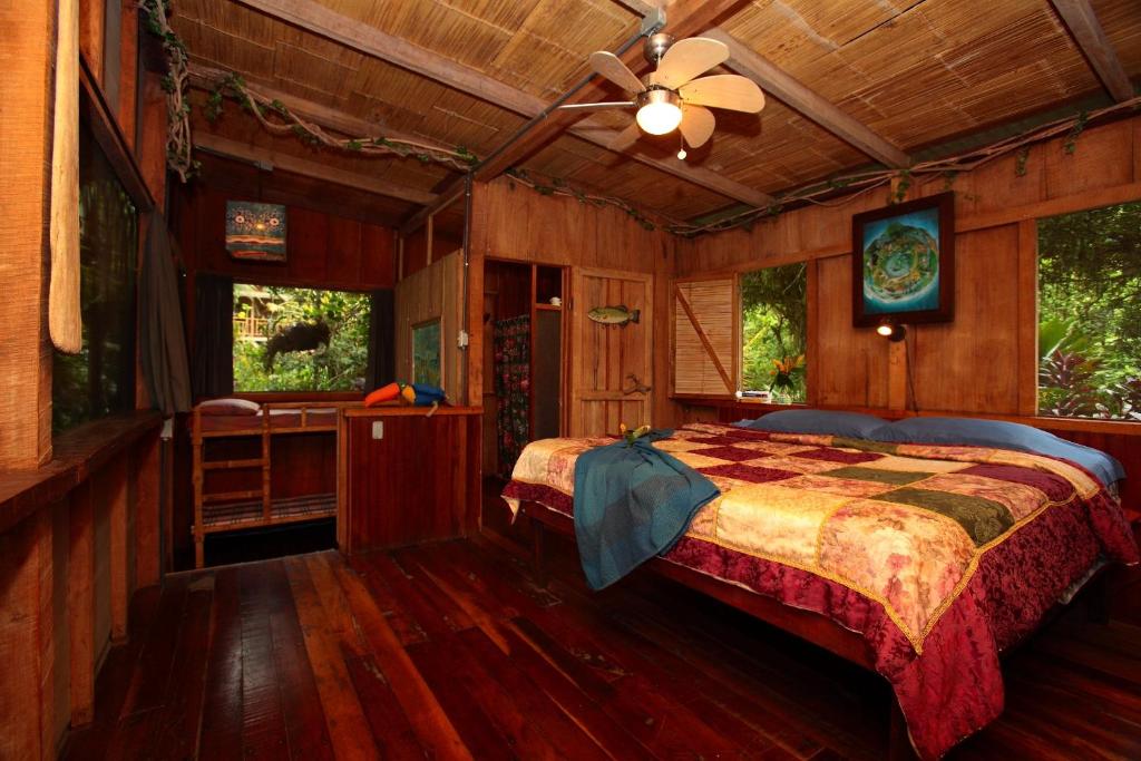1 dormitorio con 1 cama y ventilador de techo en Casa Rio Blanco Eco Friendly B&B, en Guápiles