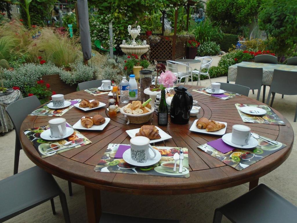 a wooden table with plates of food on it at La Petalerie Appartements d'hôtes in Épernay