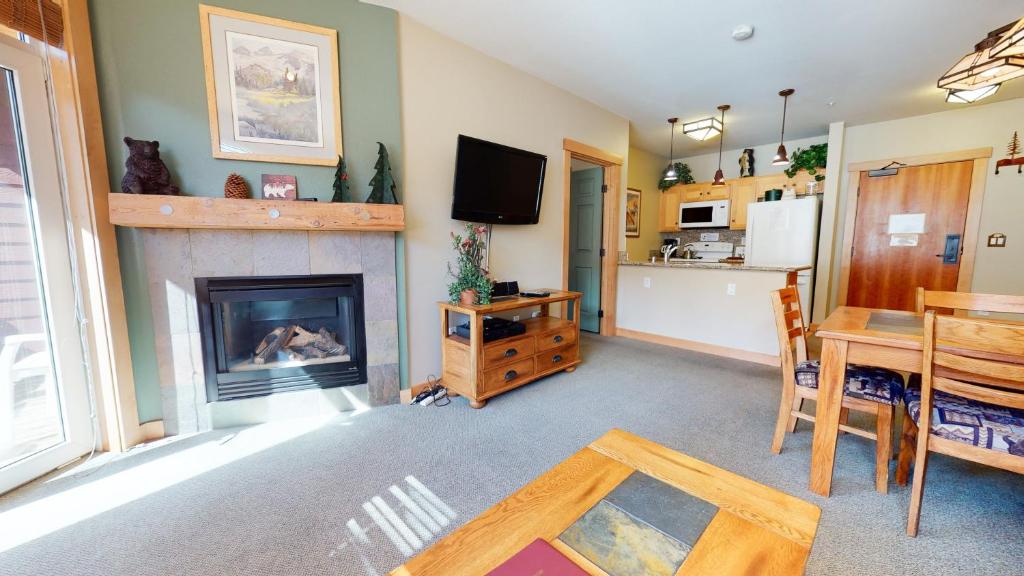 a living room with a fireplace and a table at Sunstone #208 Condo in Mammoth Lakes