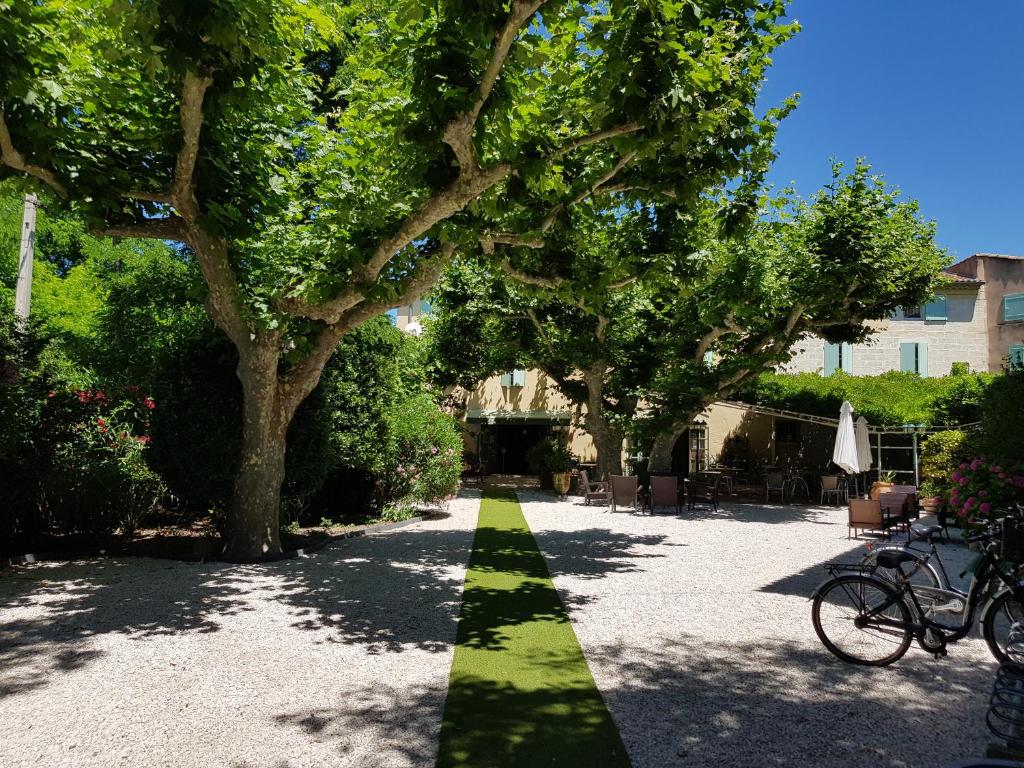 einen Gehweg mit einer grünen Linie im Hof in der Unterkunft Logis Hotel Restaurant la Ferme in Avignon