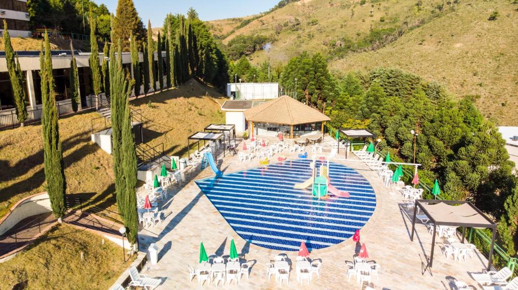 an overhead view of a pool with chairs and umbrellas at Hotel Golden Park All Inclusive Poços de Caldas in Poços de Caldas