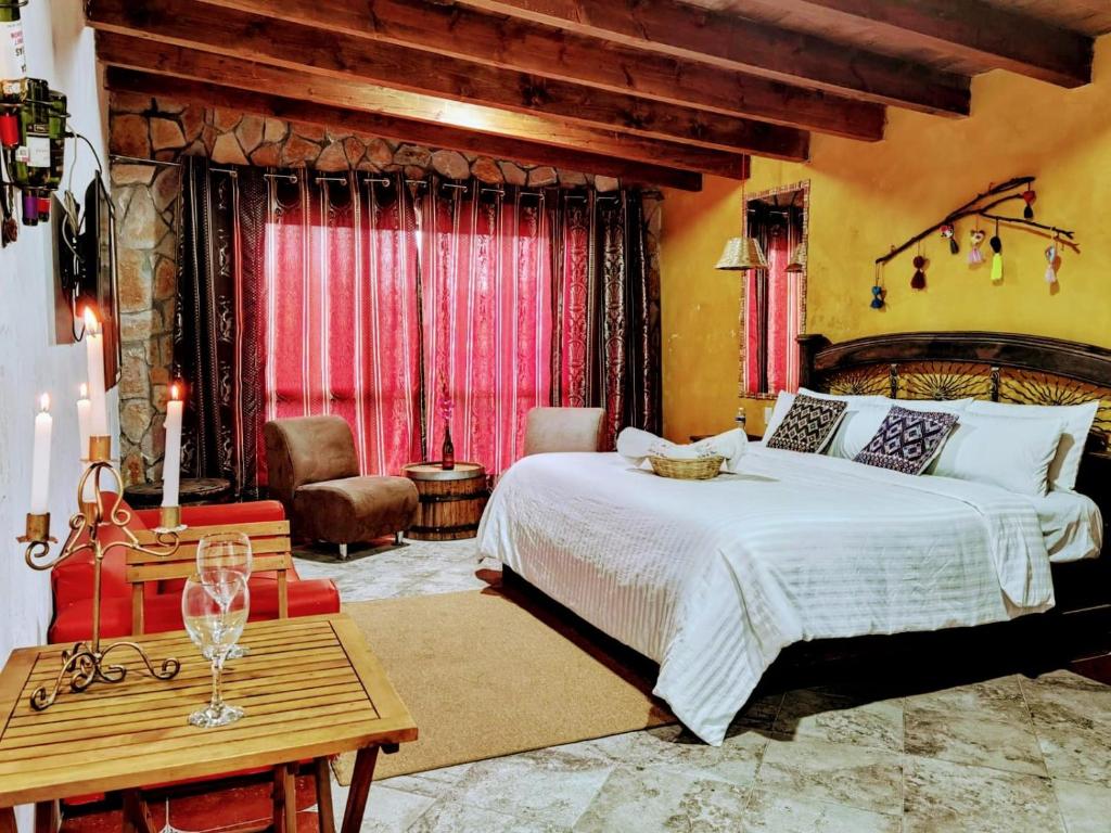 a bedroom with a large bed and a table at Hotel & Cava La Parroquia in San Cristóbal de Las Casas