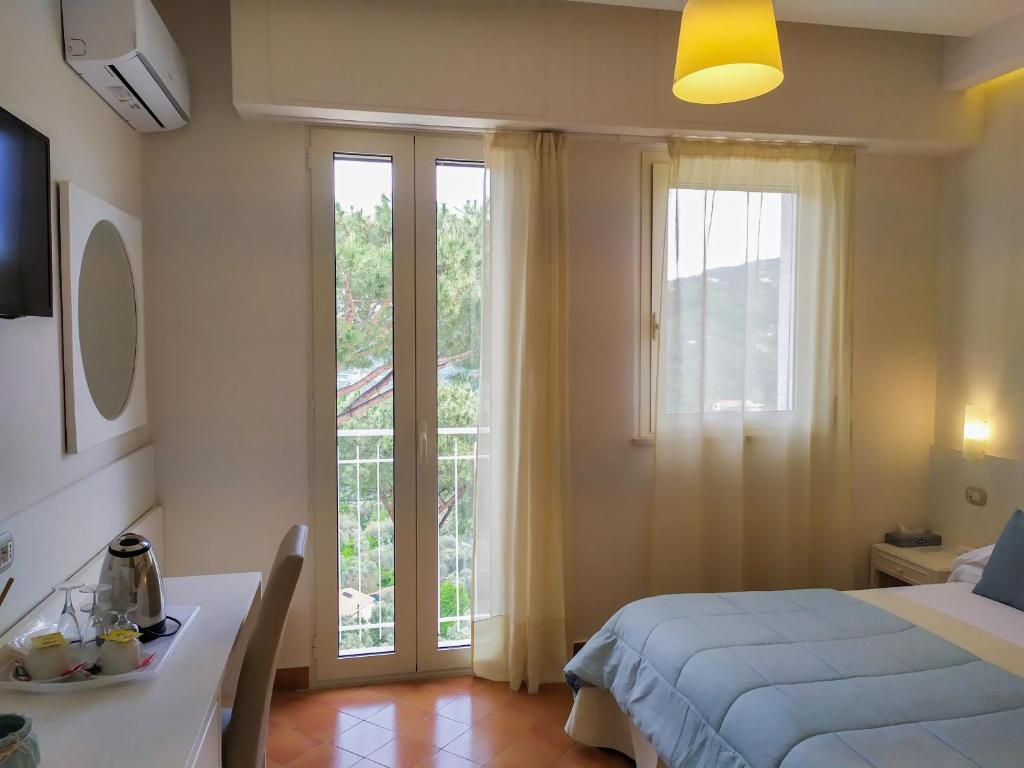 a bedroom with a bed and a table and a window at Hotel Villa Fiorita in Sorrento