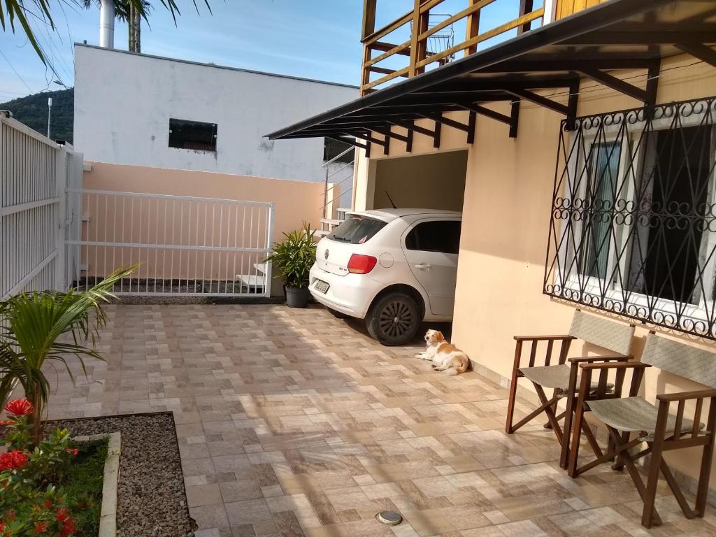 un coche aparcado en un estacionamiento junto a una casa en Enseada encantada, en Porto Belo