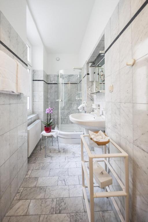 łazienka z umywalką, wanną i toaletą w obiekcie Mondial Appartement Hotel w Wiedniu
