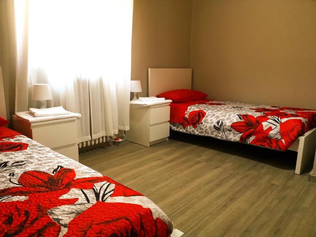 ein Schlafzimmer mit zwei Betten mit roten Blumen drauf in der Unterkunft Antica Compsa in Conza di Campania