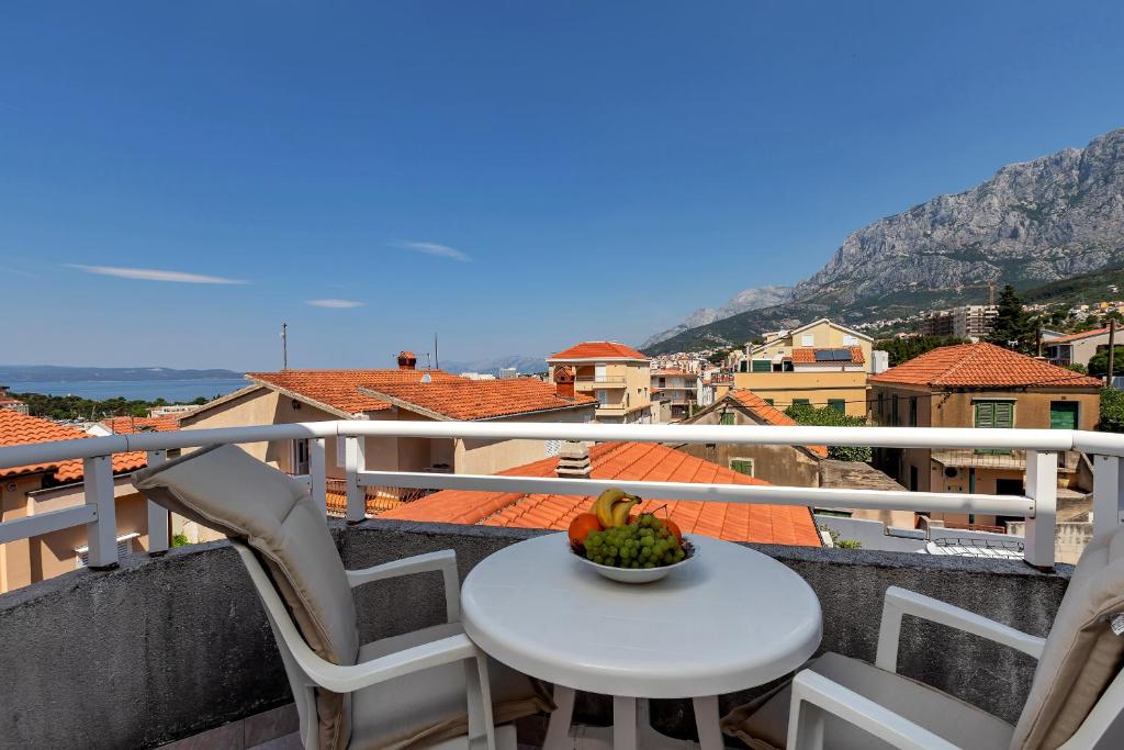 a table with a bowl of fruit on a balcony at Residence Apartments in Makarska