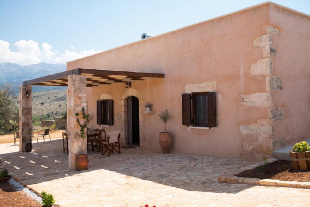 un edificio con un patio con mesa y sillas en Iliopetra Villa, en Beritianá