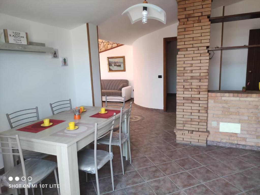 a dining room with a white table and chairs at Casa Vacanza Riviera dei Saraceni in Trebisacce