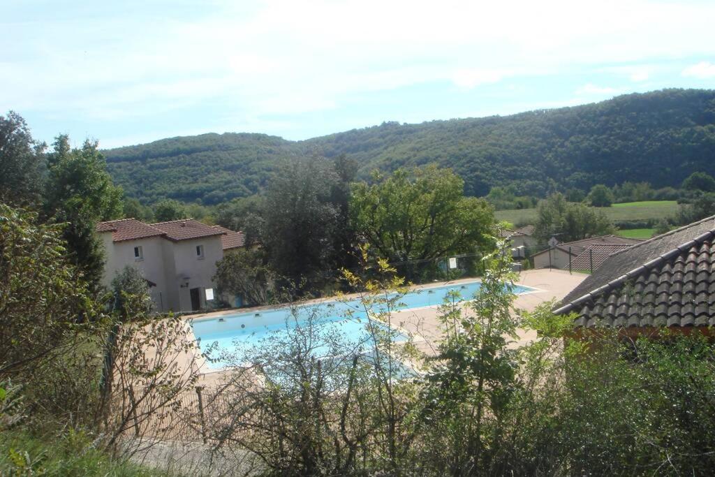 a swimming pool with a mountain in the background at location maison à Cajarc 46160 (Lot) in Cajarc