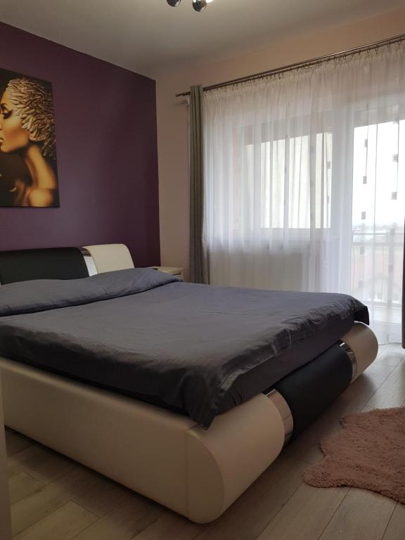 a large bed in a bedroom with a window at Arrami Aparthotel in Satu Mare