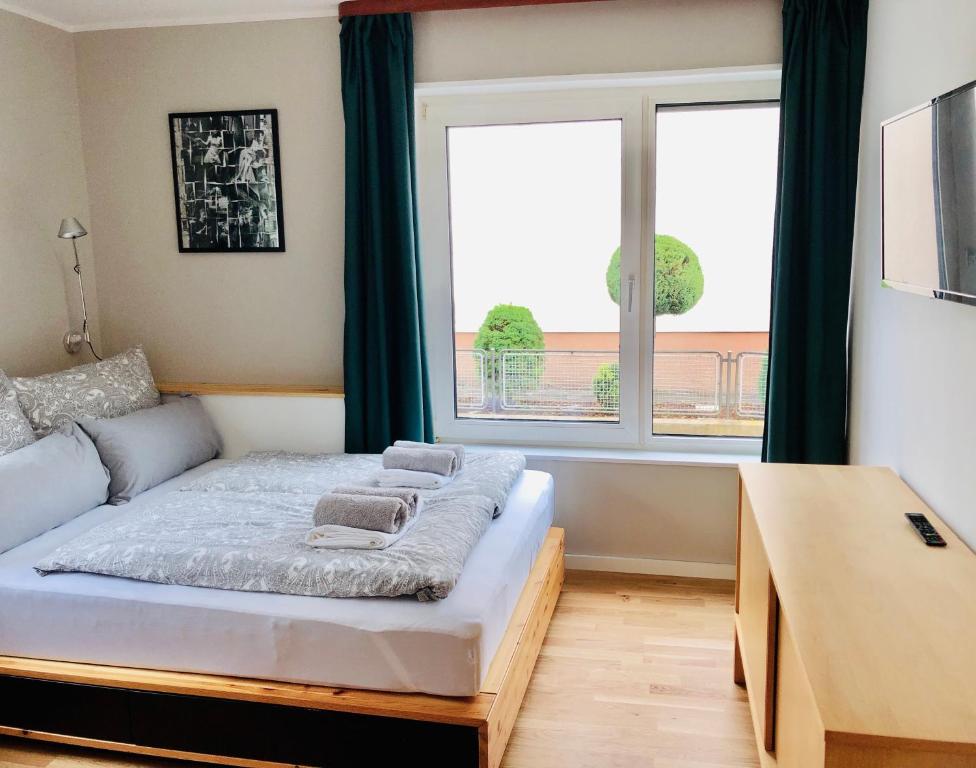 a bedroom with a bed and a large window at urbanAPARTMENT No.1 Memmingen in Memmingen