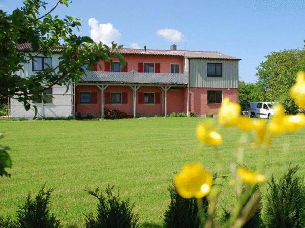 諾西茨的住宿－盧格茵斯蘭德哇森巴克酒店，一座在田野上,在前面有黄色花朵的房子