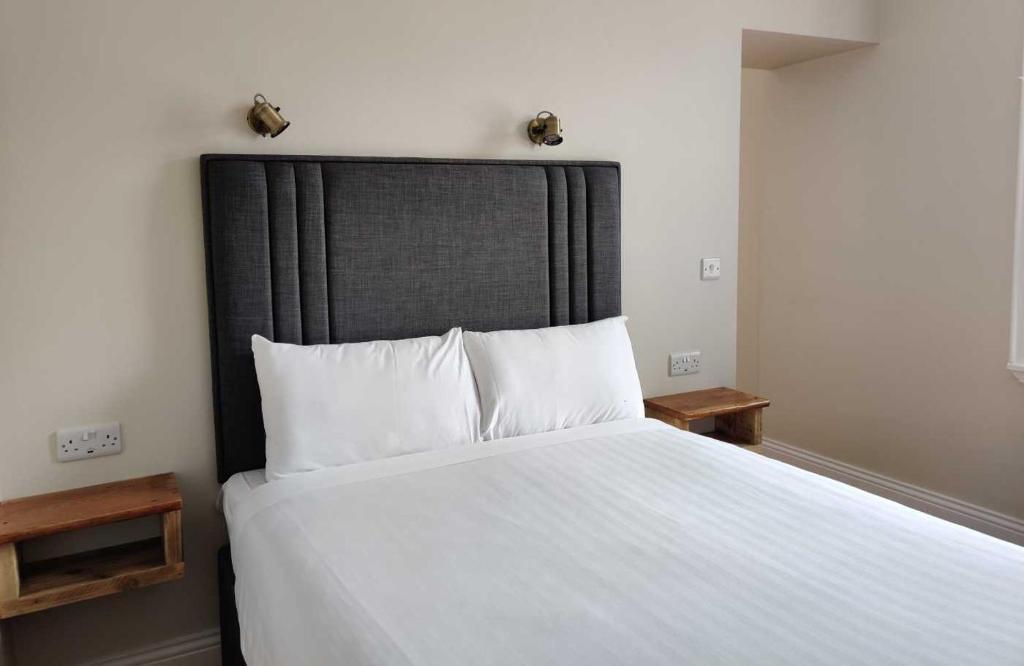 a bedroom with a large bed with white sheets and pillows at Number 53 in Galway