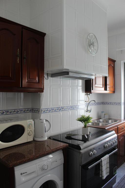a kitchen with a stove top oven and a microwave at Two bedroom apartment, two minutes from the beach in Nazaré