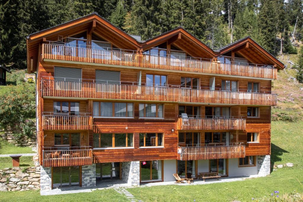 un grand bâtiment en bois avec balcon. dans l'établissement Apartment Caspar, à Riederalp