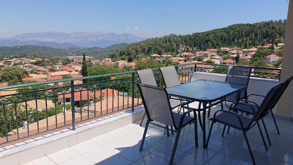 a table and chairs on a balcony with a view at House of Aggelos - Karya Lefkadas in Kariá