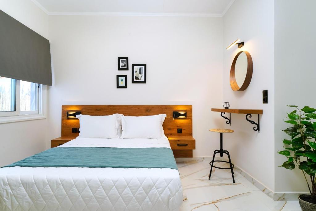 a white bedroom with a bed and a table at Relax Studios in Limenaria