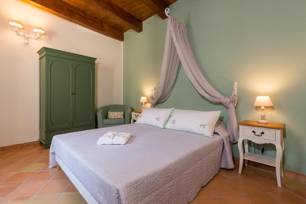 - une chambre avec un lit à baldaquin vert dans l'établissement Palazzo Don Carlo, à Morigerati