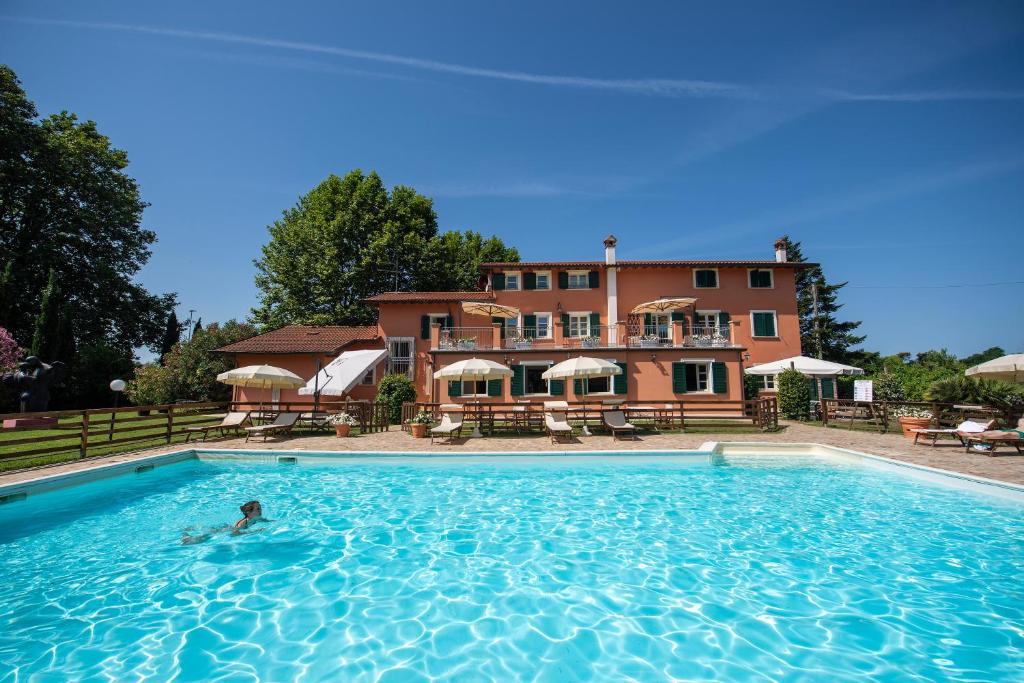 a person in a swimming pool in front of a building at Relais Villa Isabel in Pietrasanta
