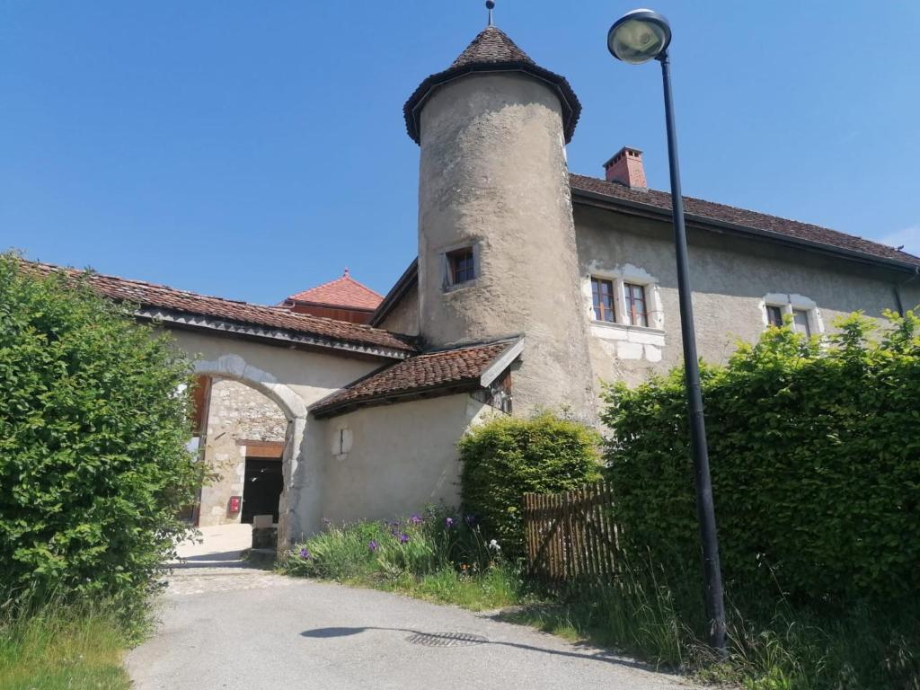 a building with a tower on the side of it at Le Domaine du Château in Seynod