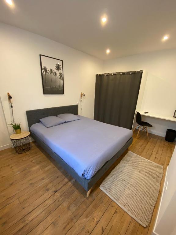 a bedroom with a large bed and a desk at Appartement 97 M2 proche Puy du fou in Saint-Laurent-sur-Sèvre