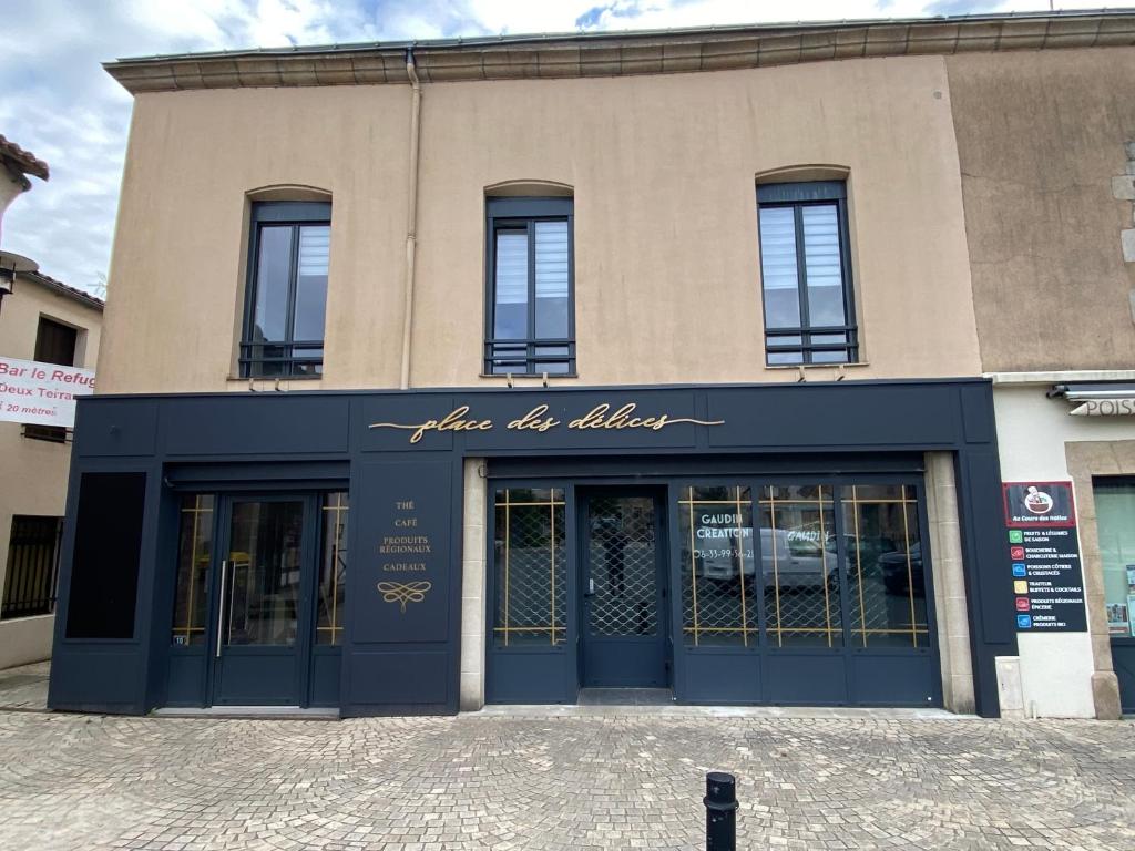 a store front of a building with blue doors at Appartement 97 M2 proche Puy du fou in Saint-Laurent-sur-Sèvre