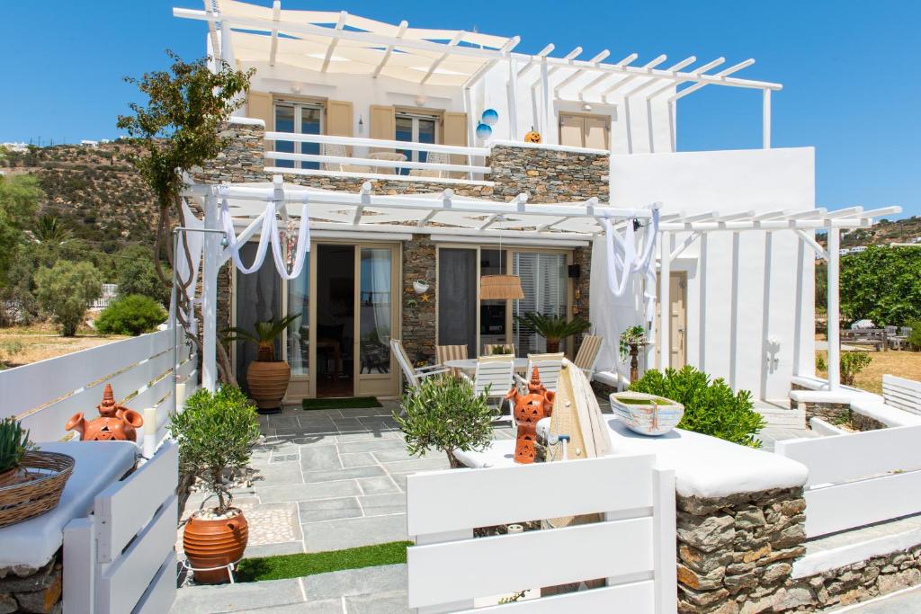 una casa blanca con una valla blanca en Miles Away Sifnos - Beachfront House en Platis Yialos Sifnos