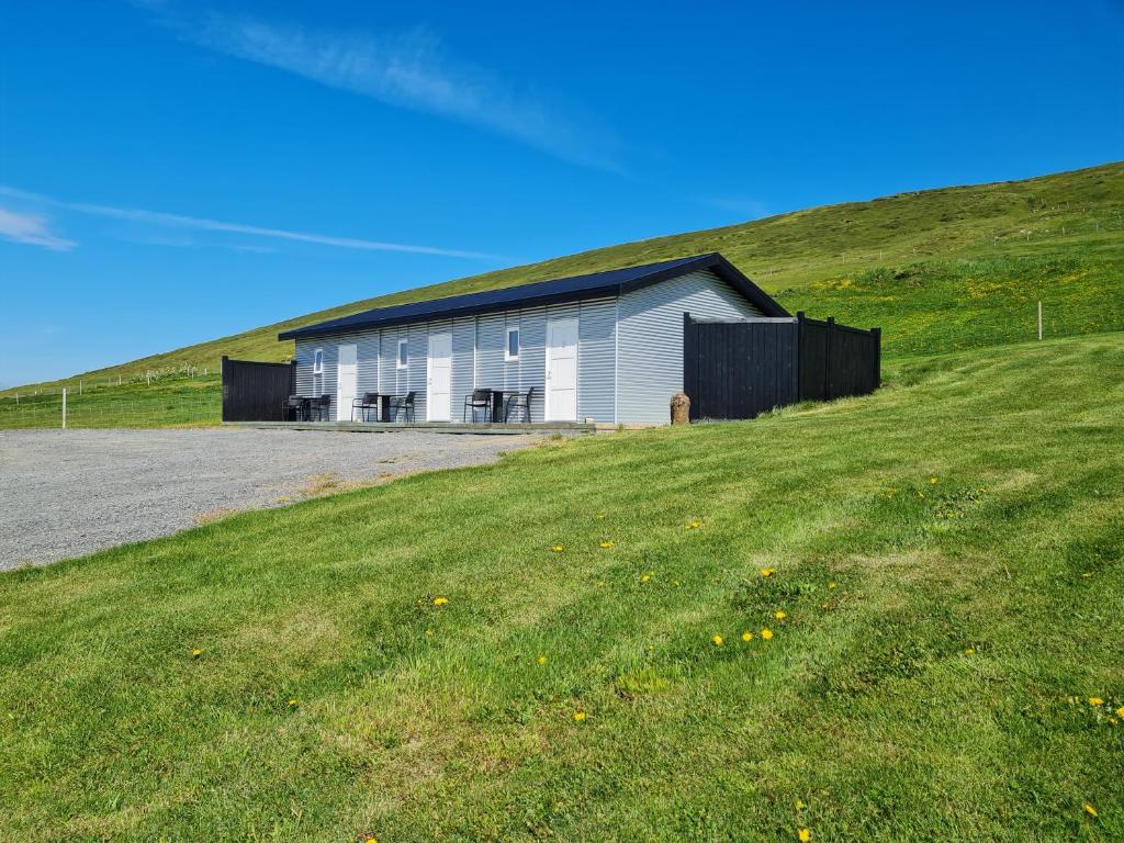 a white building on top of a grassy hill at Guesthouse Brúnahlíð in Aðaldalur