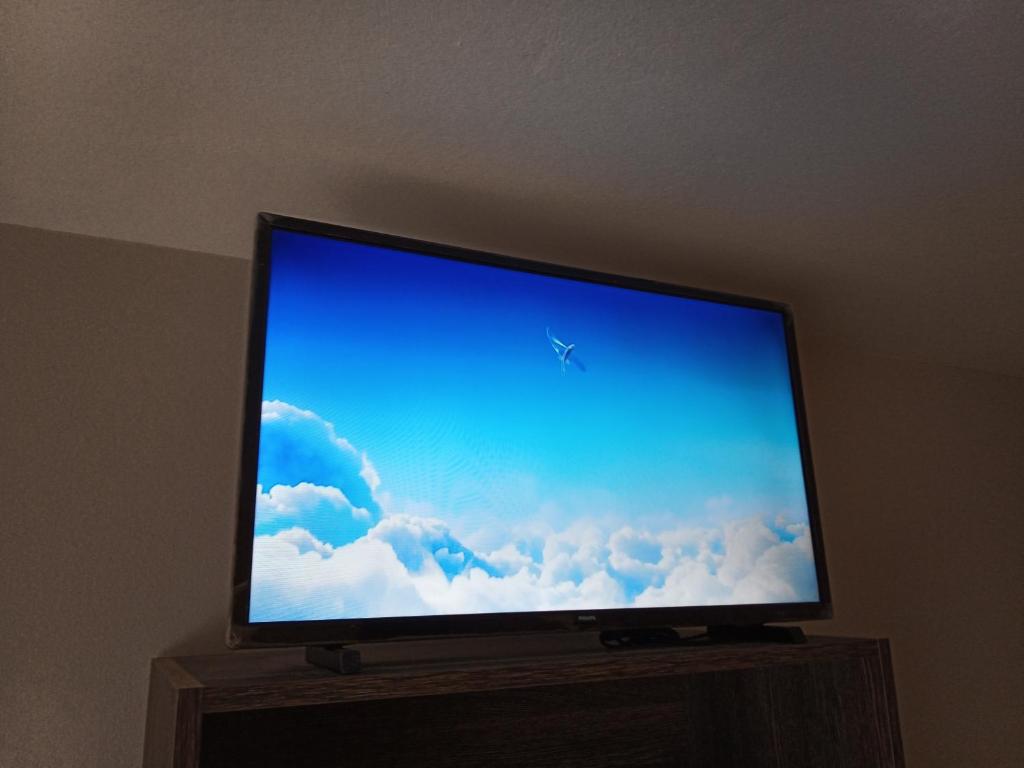 TV de pantalla plana con soporte de madera en Pension KM66, en Palas de Rei 