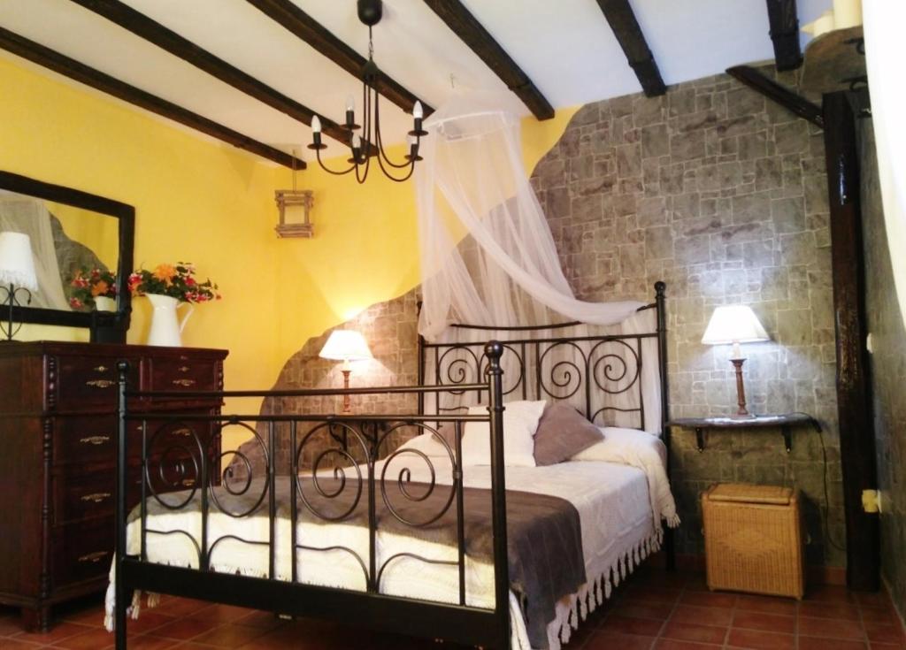 a bedroom with a bed and a dresser with a canopy at Casa Rural Albarranco in Prádena de Atienza