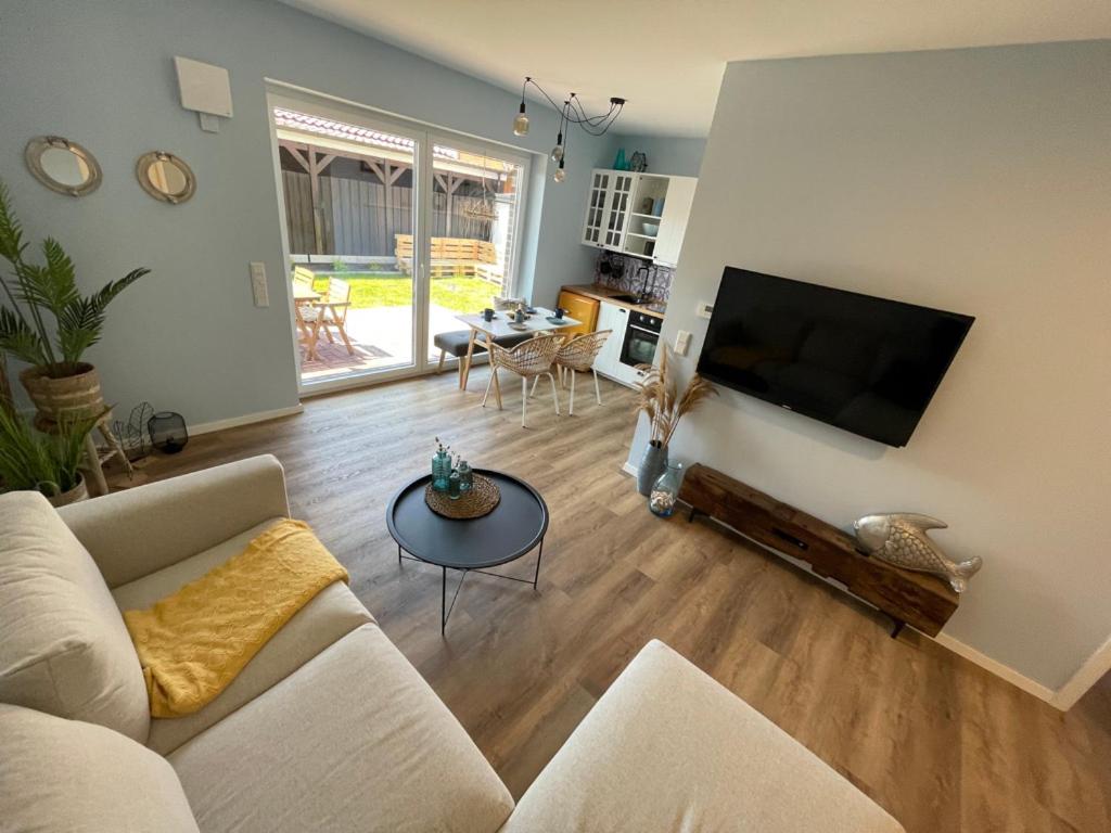 un soggiorno con divano e TV a schermo piatto di Fewo Lieblingsort Norddeich a Norddeich