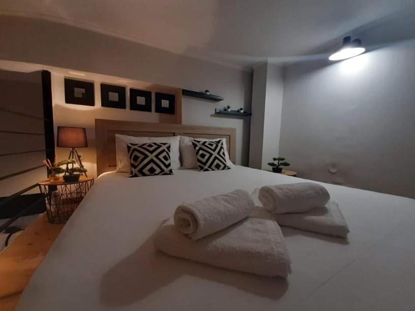 a bedroom with a large white bed with towels on it at Speri's Loft in Preveza