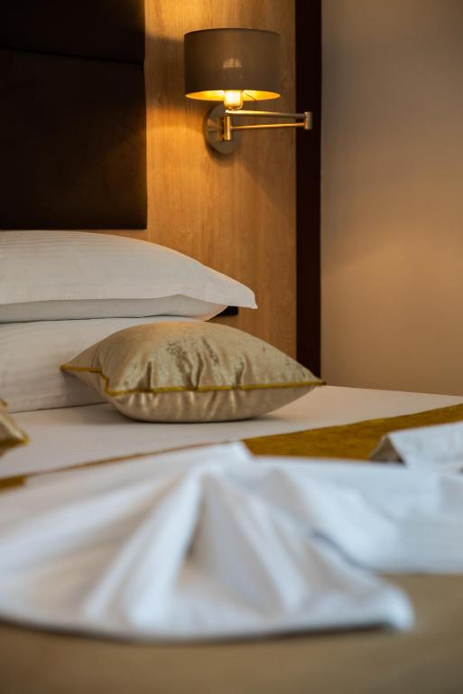 a bed with a pillow and a lamp on it at Hotel Meduza in Senj