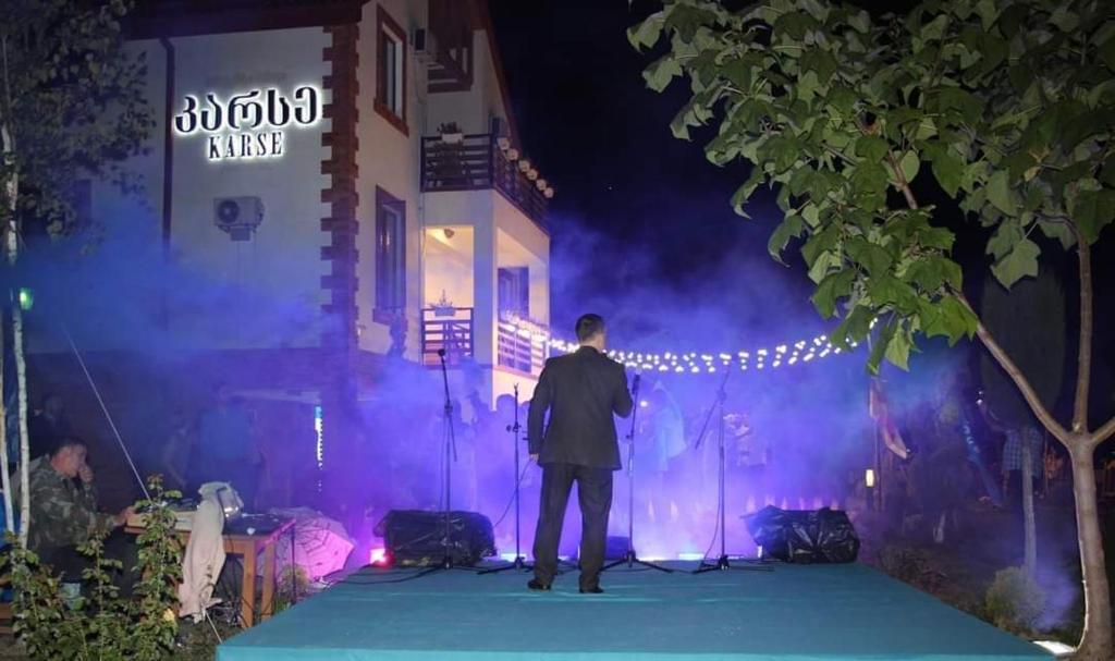 a man standing on a stage at night at Karse in Ambrolauri