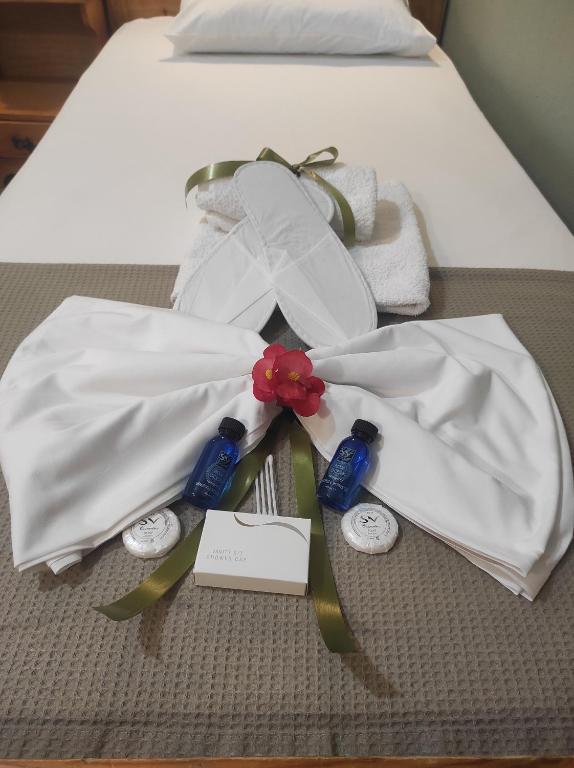łóżko z dwoma białymi sukniami ślubnymi i kartą w obiekcie Prosforio w mieście Uranupoli