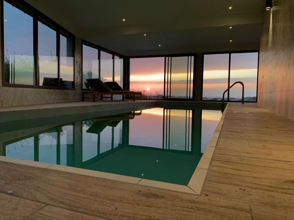 una piscina en una casa con vistas a la puesta de sol en Les Villas d'Onalou - Bugueles en Port-Blanc